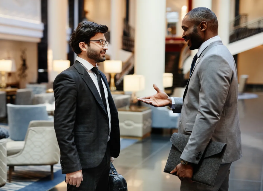 Two businessmen talking in a hotel lobby.