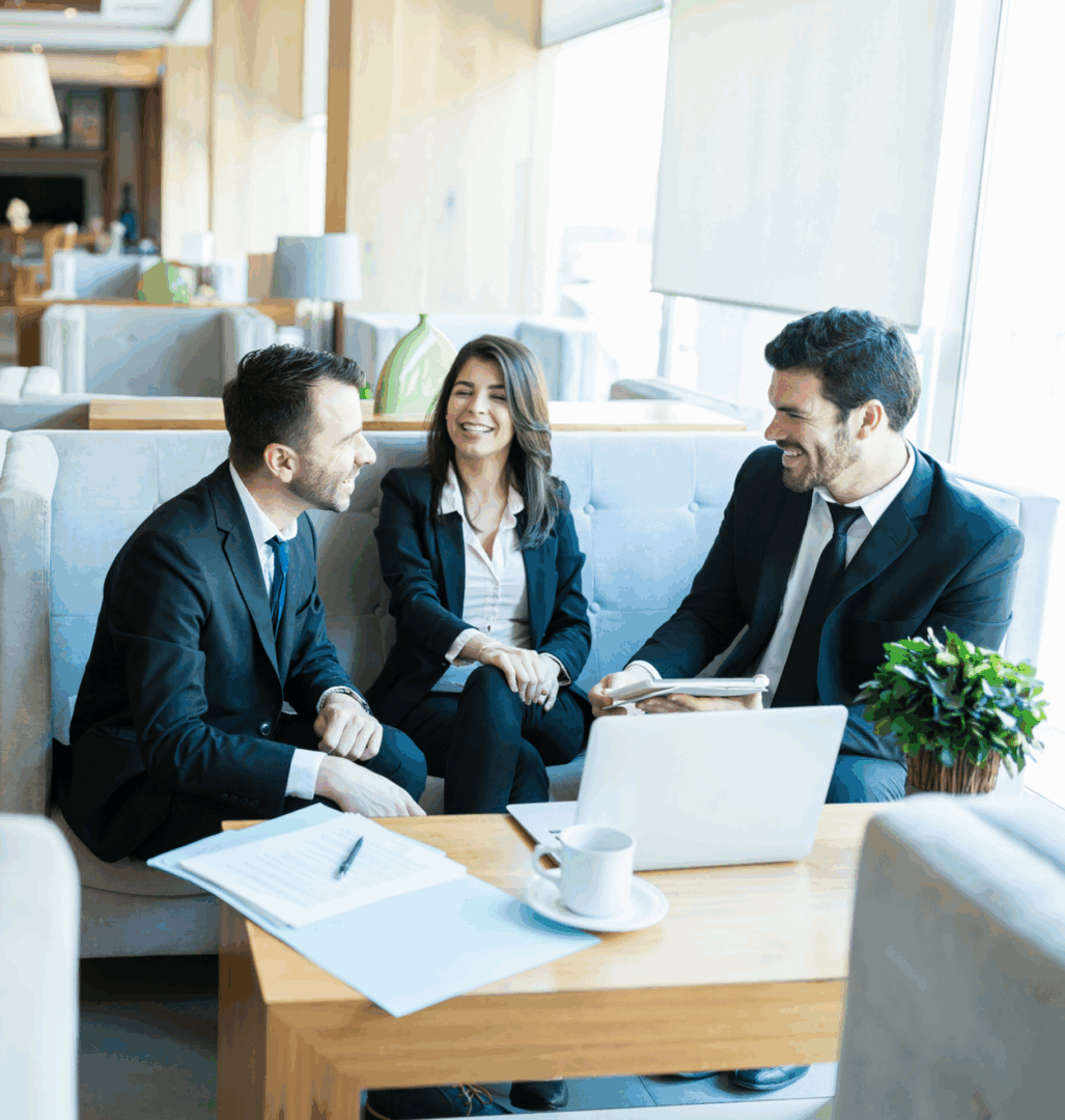 Business meeting with three people smiling.